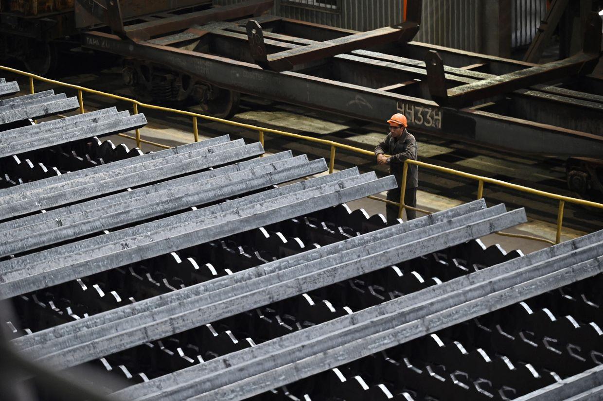 An employee looks at newly made cooled billets on a continuous caster machine at the ArcelorMittal Kryvyj Rih factory 