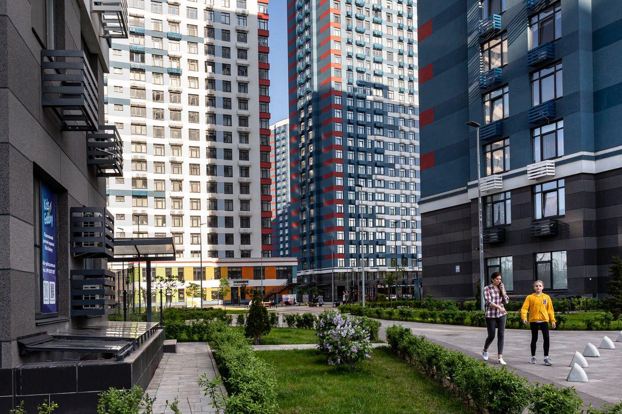 Residents walk in the common area between large residential blocks