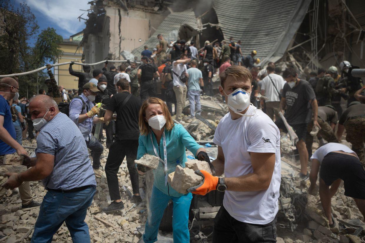 People clear rubble from a building at one of the largest children’s hospitals of Ukraine, ‘Okhmatdyt’