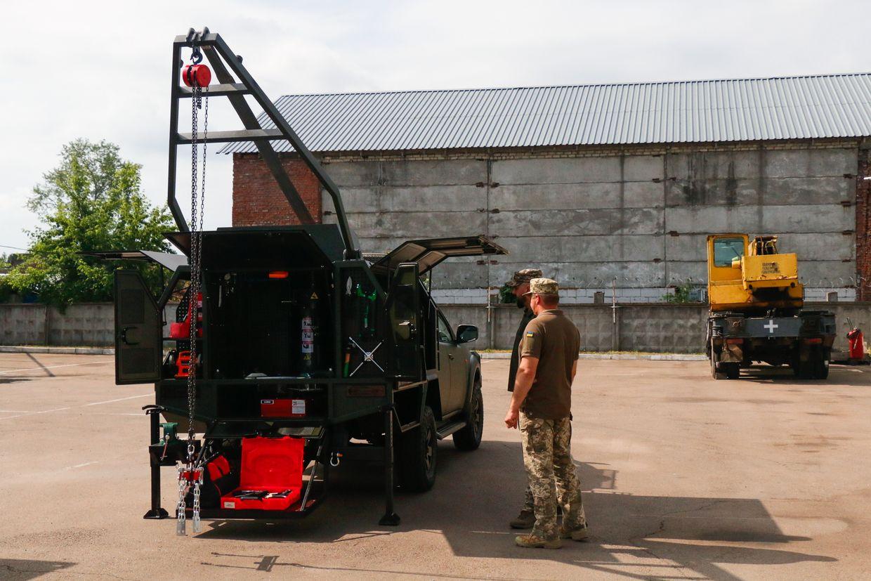 People stand near the mobile repair workshop in Chernihiv, Ukraine, on June 7, 2024. 