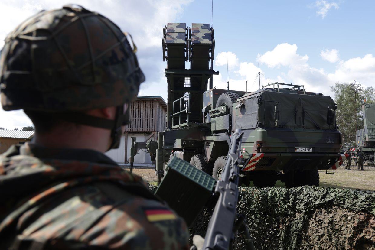 A German reservist stands next to a Patriot launcher.