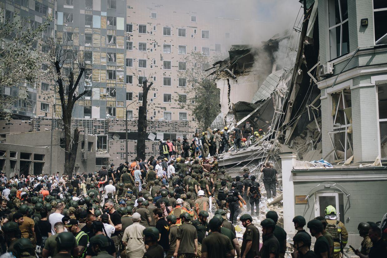 People clear rubble from a building of one of the largest children’s hospitals of Ukraine, ‘Okhmatdyt’