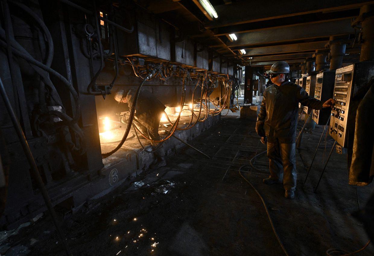 Employees work at a continuous caster machine at the ArcelorMittal Kryvyj Rih integrated steel company's factory