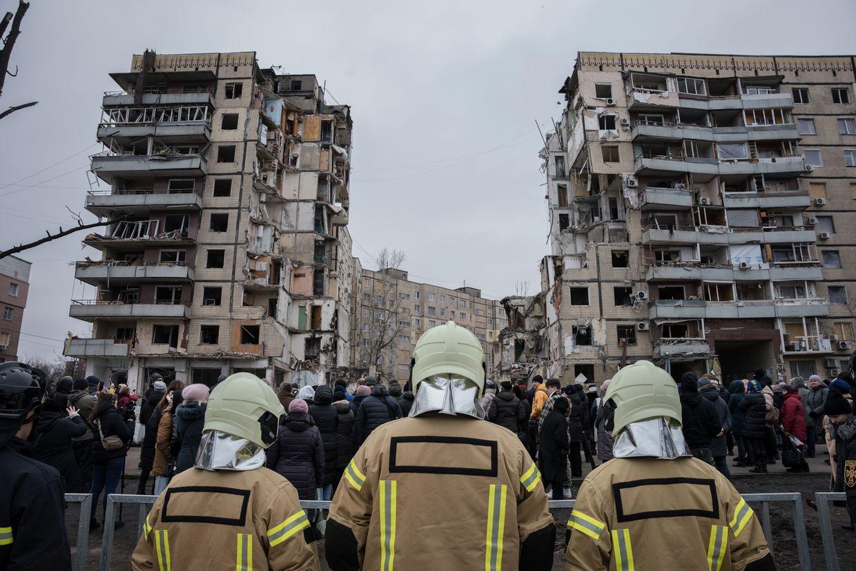  Firefighters stand before a building bombed on Jan. 14 as they work in Dnipro, Ukraine, on Jan. 22, 2023.