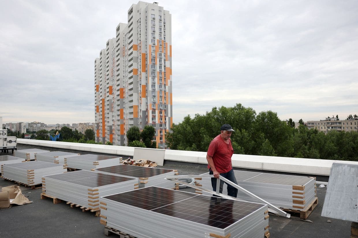 A worker installs solar panels in Kyiv, Ukraine on June 14, 2024. (Anatolii Stepanov / AFP via Getty Images)