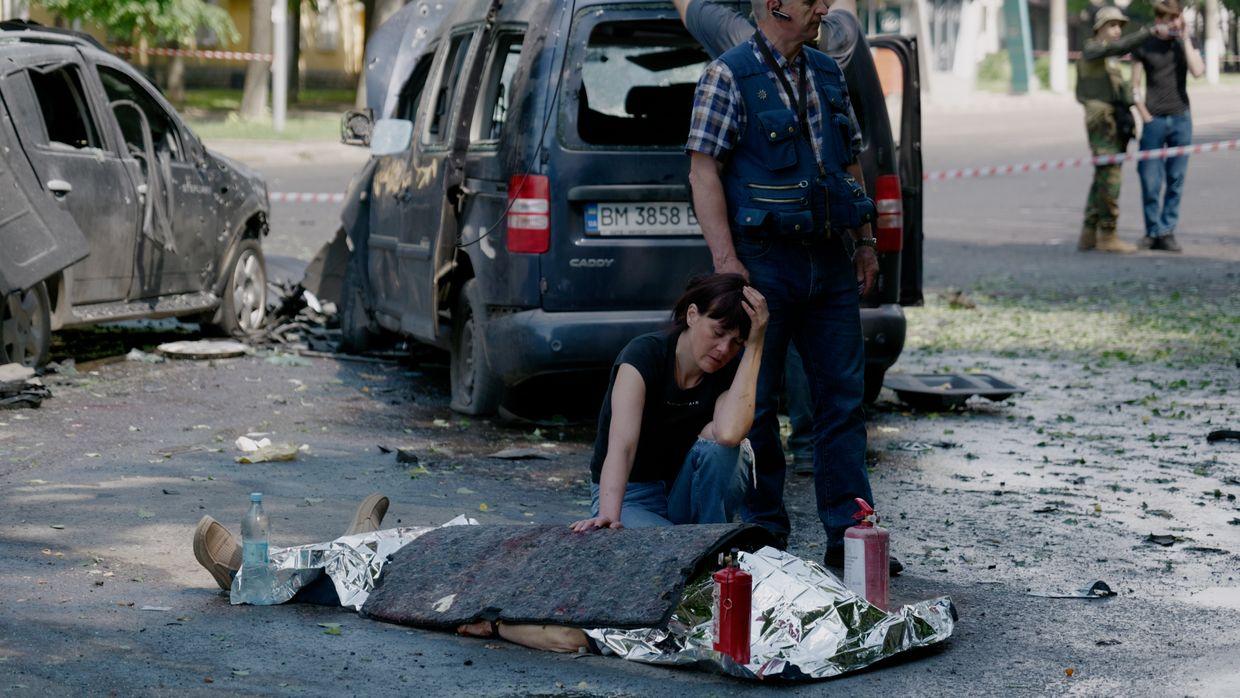 A woman mourns next to a body after a Russian multiple rocket attack on Sumy, Ukraine, on June 3, 2025. 