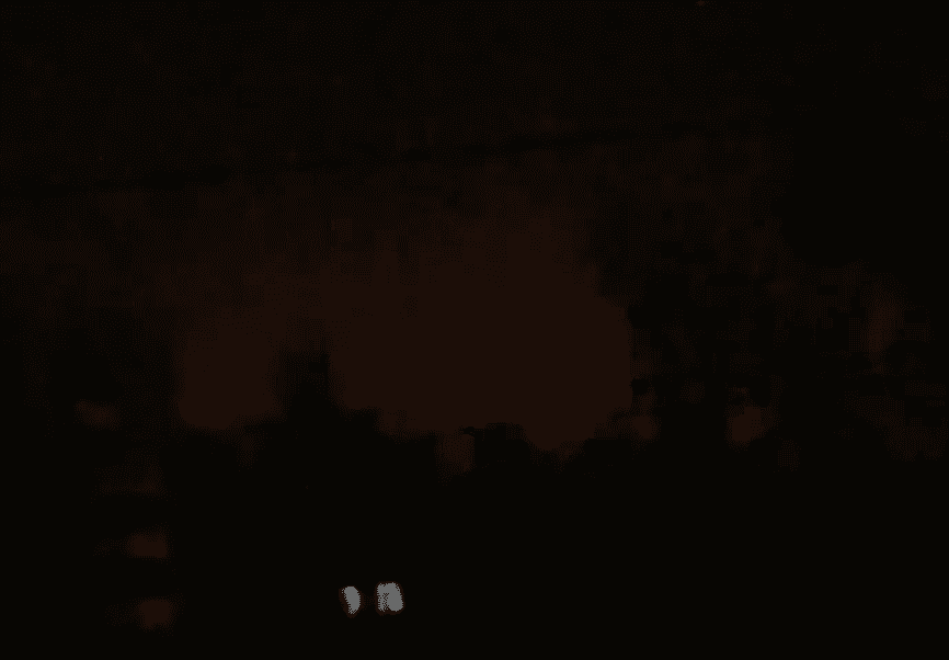 The reported feint glow of a fire buring in the distance under a dark, night sky