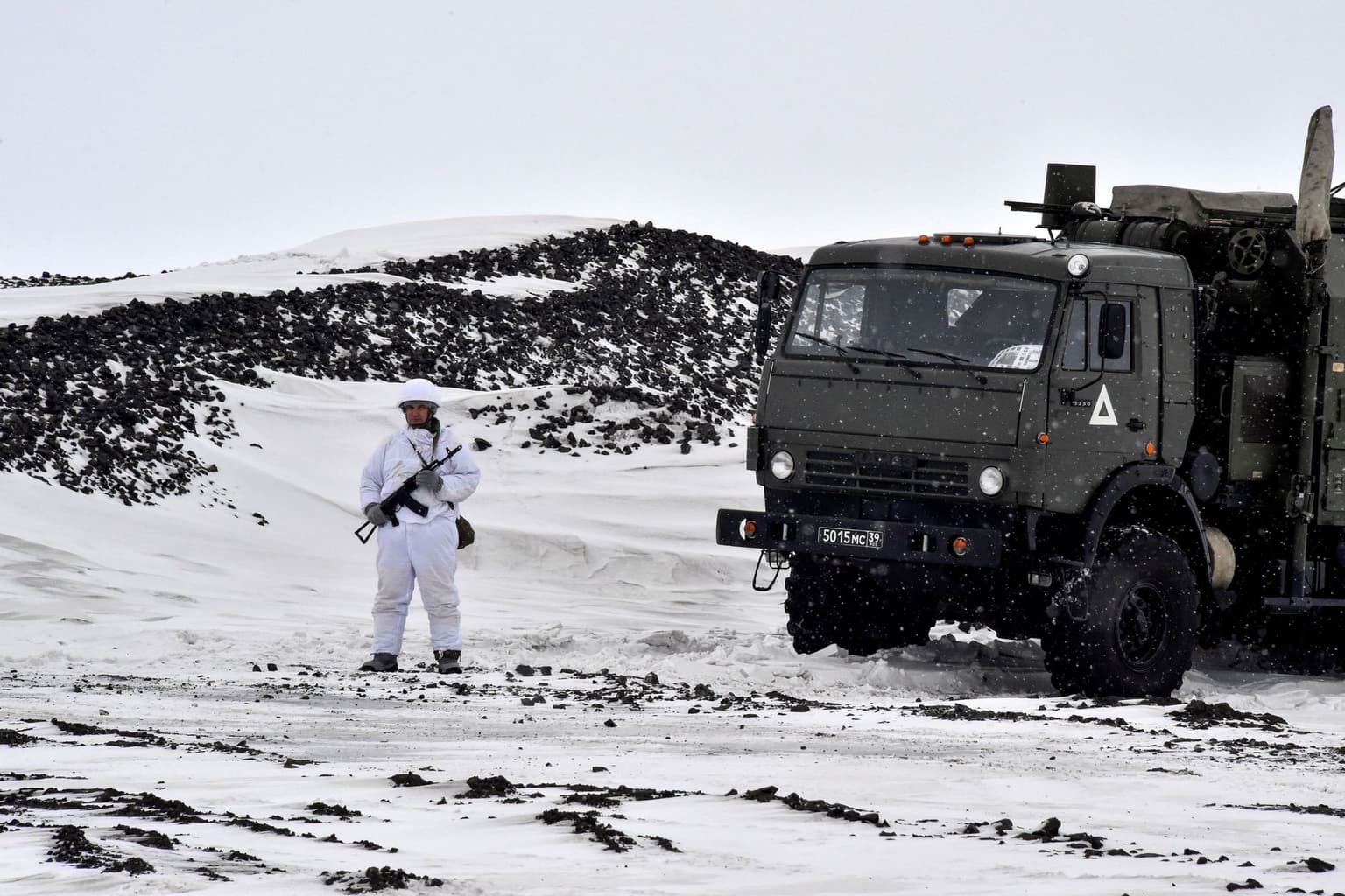 A Russian serviceman stands guard by a military truck part of the Franz Josef Land archipelago, in Russia, on May 17, 2021. 