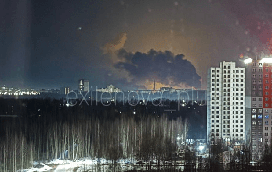 Smoke rises from a fire in the distance behind a cityscape