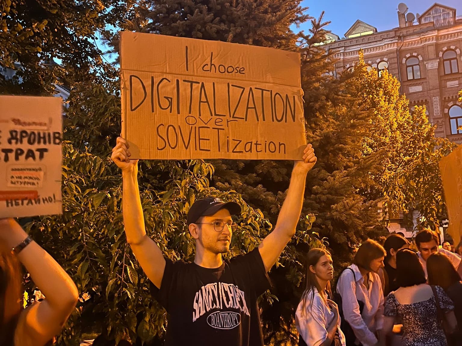 A protestor holds up a sign reading "I choose DIGITILIZATION over SOVIETization"