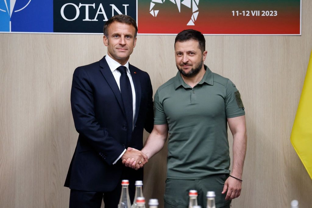 French President Emmanuel Macron shakes hands with President Volodymyr Zelensky.