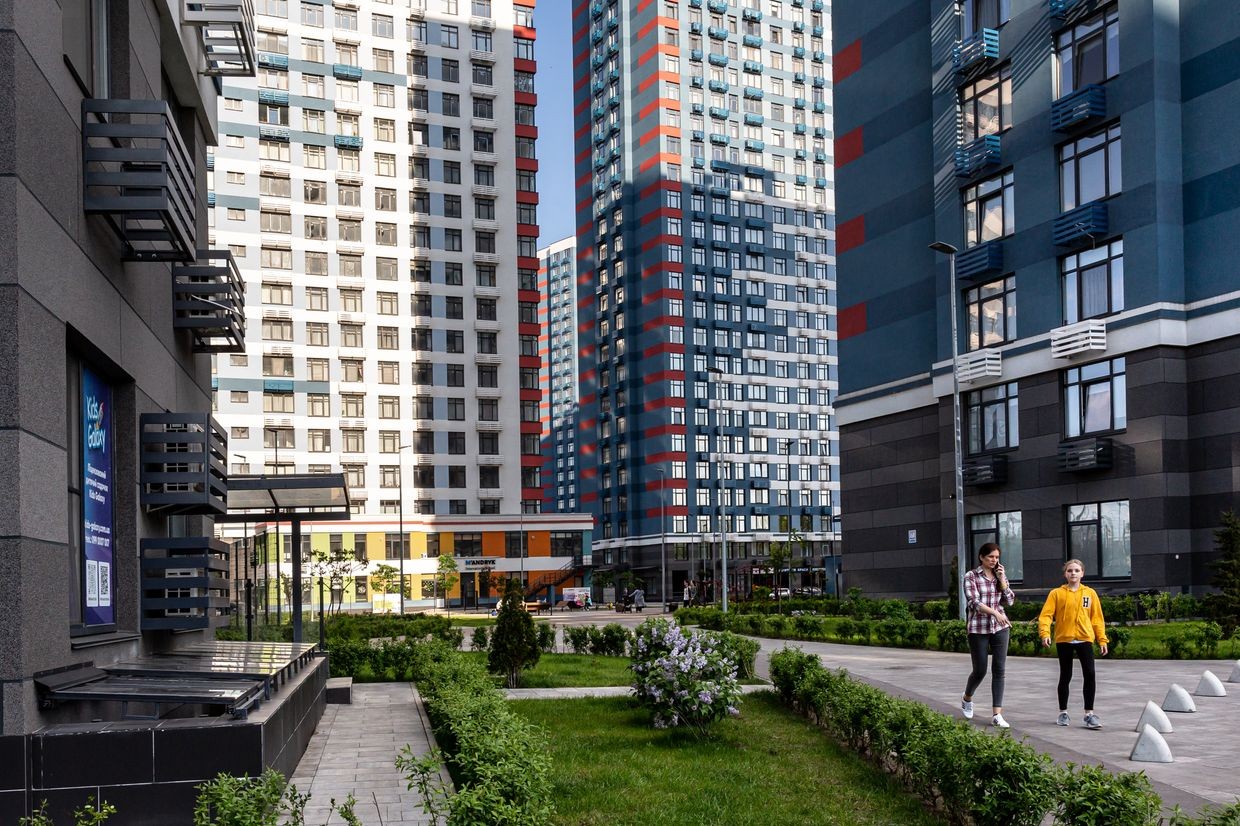 Residents walk in the common area between large residential blocks
