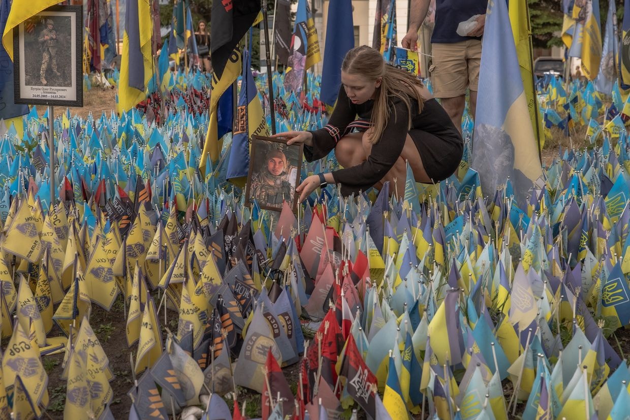 A woman holds a portrait at a memorial for fallen Ukrainian and foreign fighters in Kyiv, Ukraine, on May 27, 2024. 
