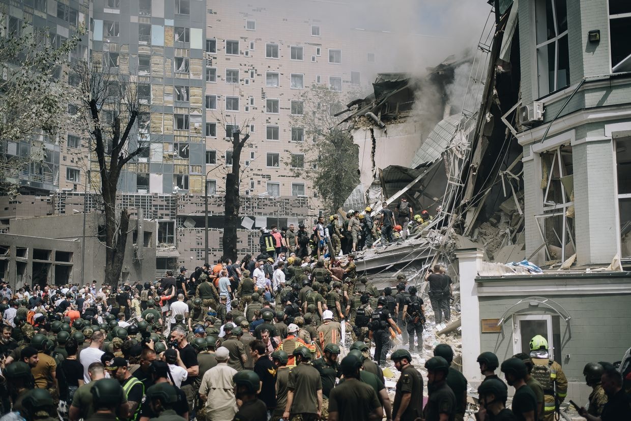 People clear rubble from a building of one of the largest children’s hospitals of Ukraine, ‘Okhmatdyt’