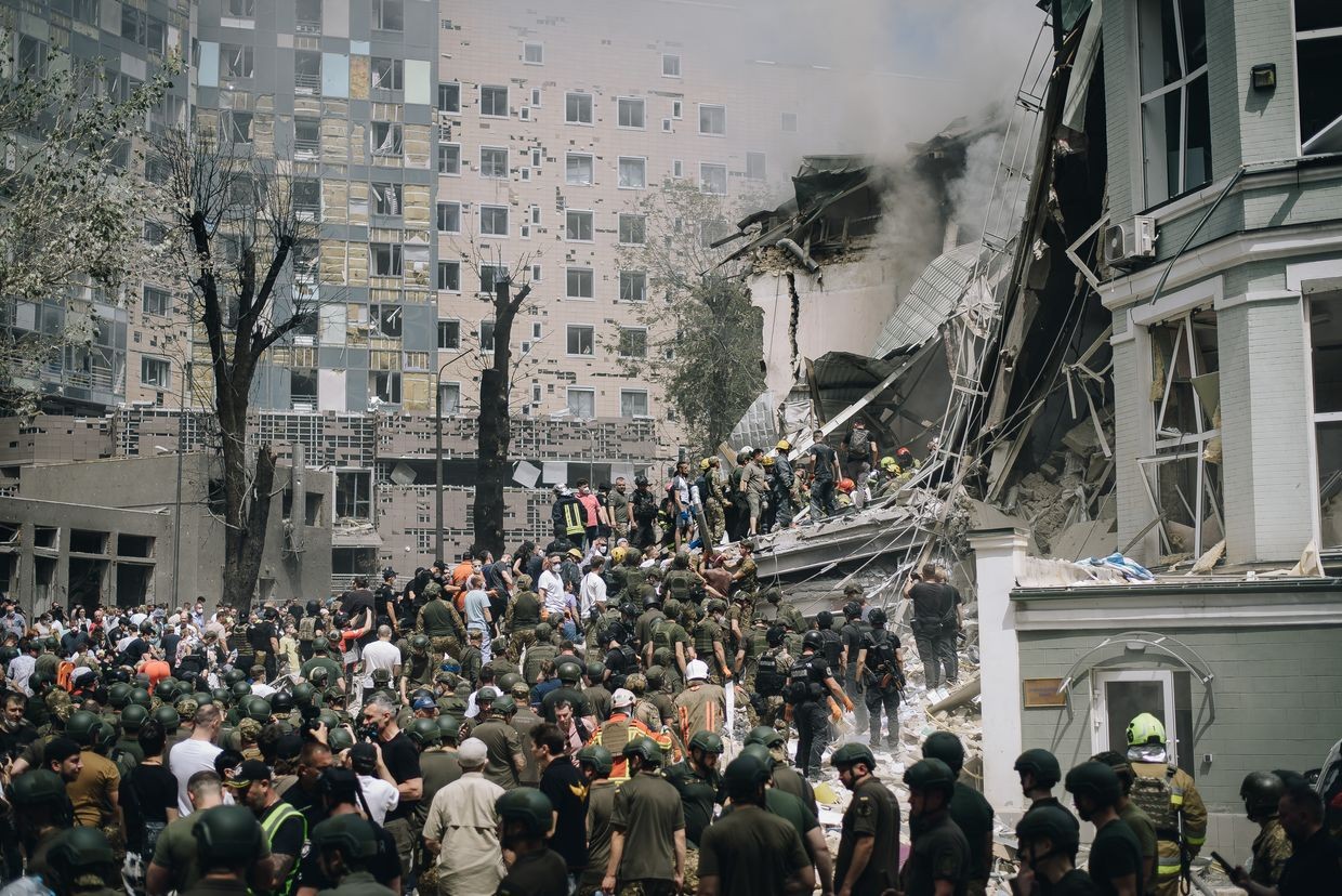 People clear rubble from a building of one of the largest children’s hospitals of Ukraine, ‘Okhmatdyt’