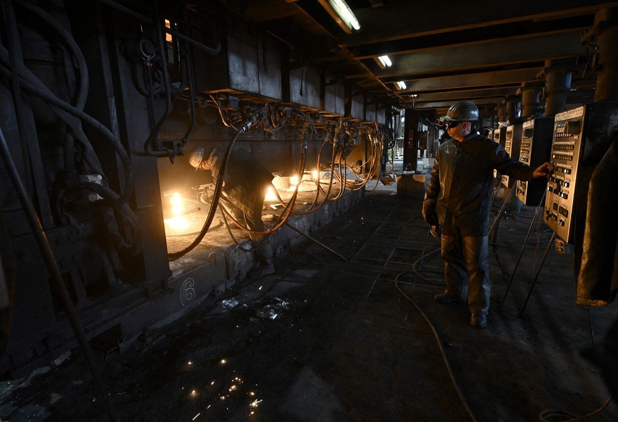Employees work at a continuous caster machine at the ArcelorMittal Kryvyj Rih integrated steel company's factory