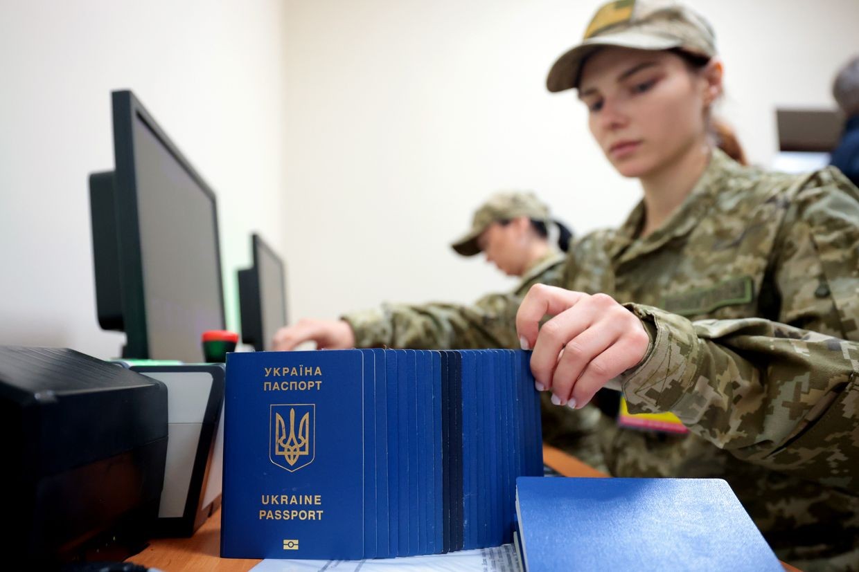 A border guard arranges Ukrainian passports at a checkpoint in Rava-Ruska, Ukraine, on Oct. 15, 2023.