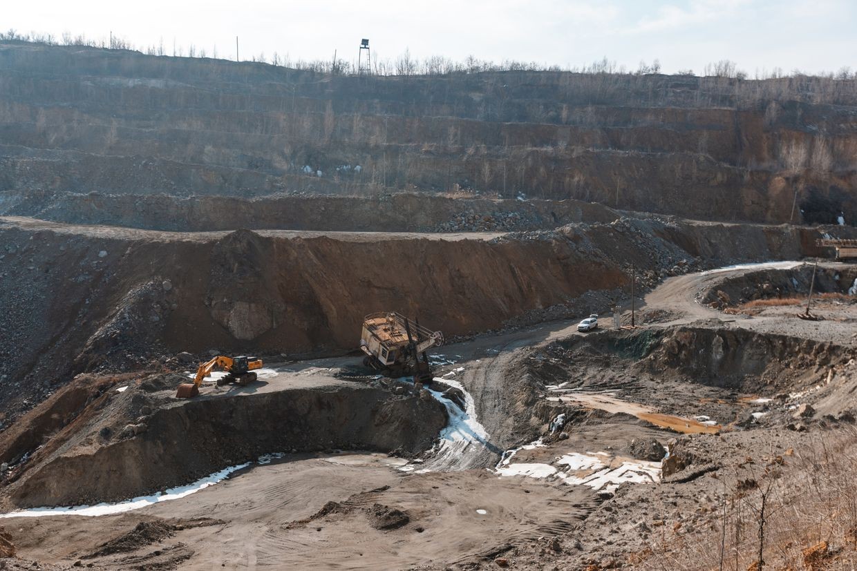 Two excavators in a mining pit at the Zavalivskiy Graphite Ltd. graphite mine in Ukraine.
