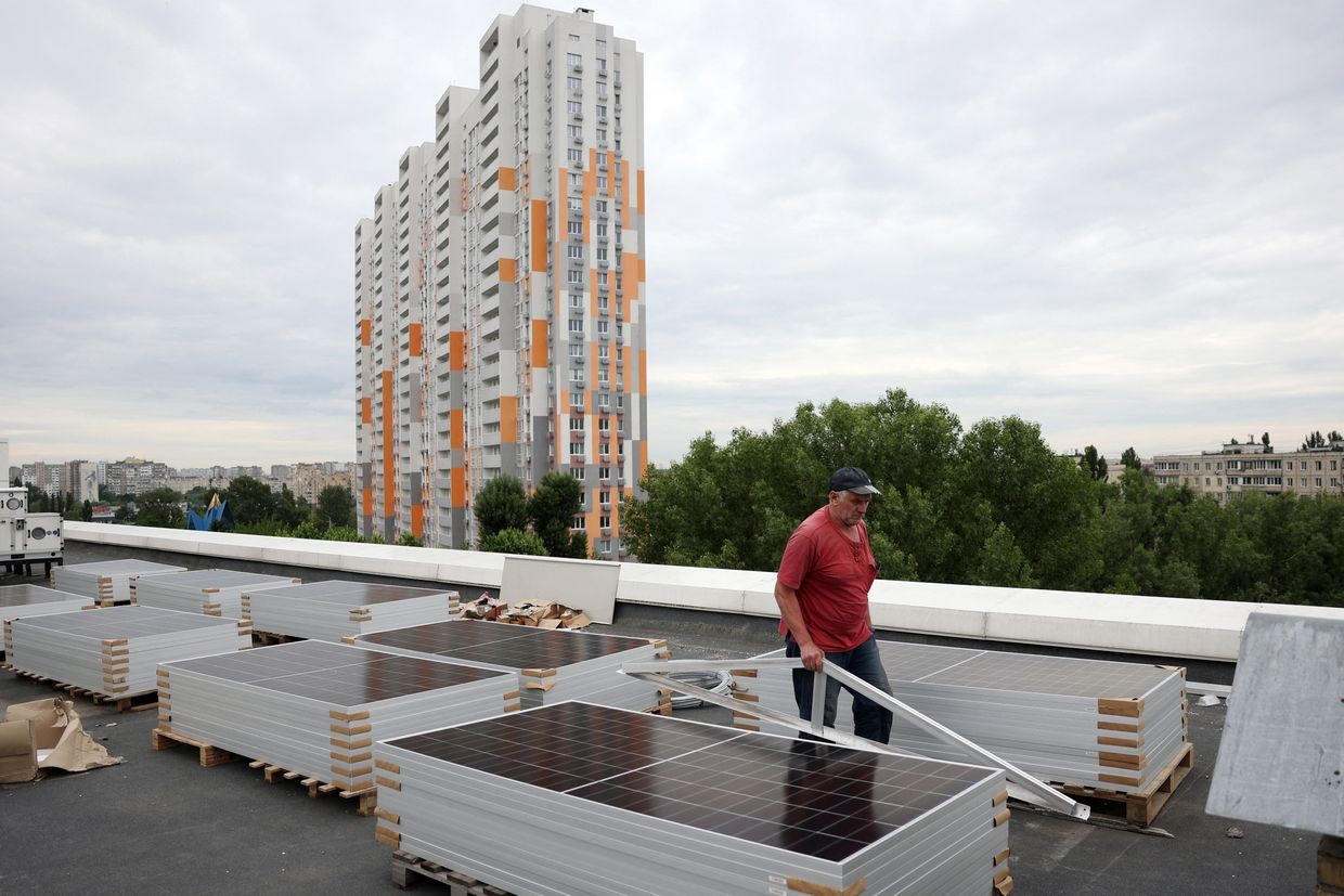 A worker installs solar panels in Kyiv, Ukraine on June 14, 2024. (Anatolii Stepanov / AFP via Getty Images)
