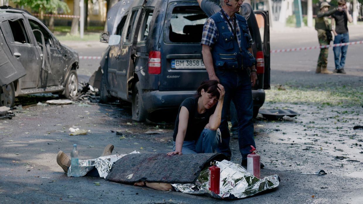 A woman mourns next to a body after a Russian multiple rocket attack on Sumy, Ukraine, on June 3, 2025. 