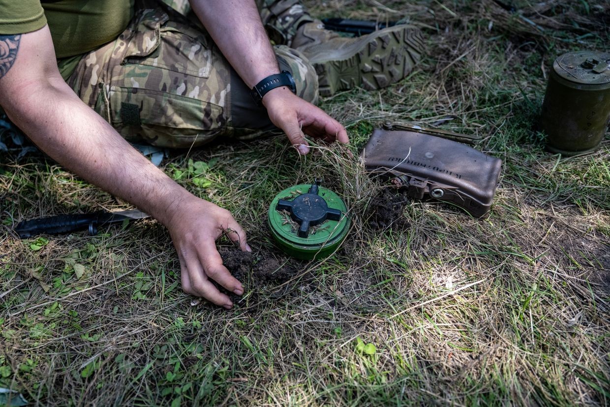 De-mining sapper demonstrates how Russian forces place an anti-personnel mine in Ukraine, on July 31, 2023. 