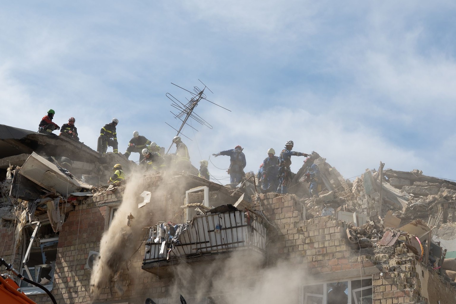 Emergency workers at the building damaged in a Russian combined attack on Kyiv, Ukraine, on Aug. 28, 2025. (Olena Zashko/The Kyiv Independent)