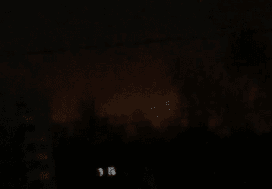 The reported feint glow of a fire buring in the distance under a dark, night sky
