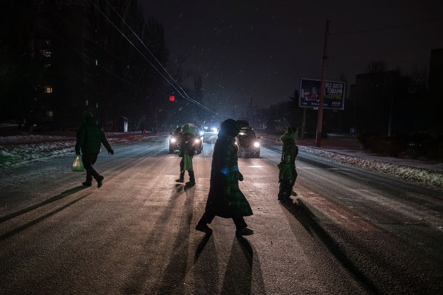 People cross a street during a power outage caused by recent Russian attacks in Kyiv, Ukraine, on Jan. 11, 2026. 