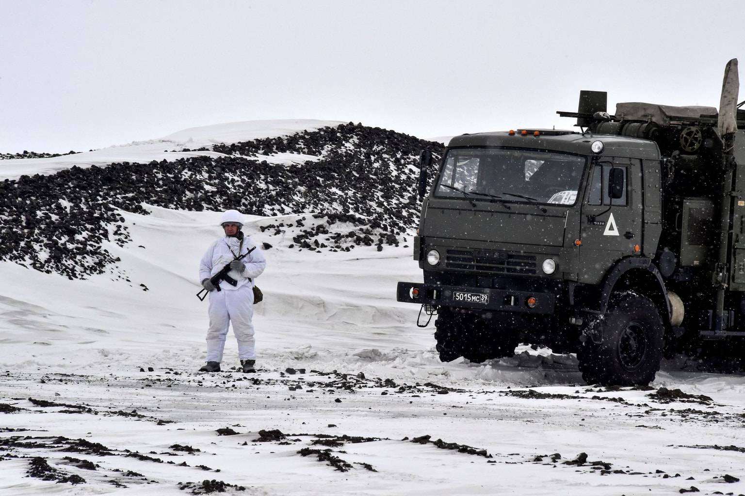 A Russian serviceman stands guard by a military truck part of the Franz Josef Land archipelago, in Russia, on May 17, 2021. 