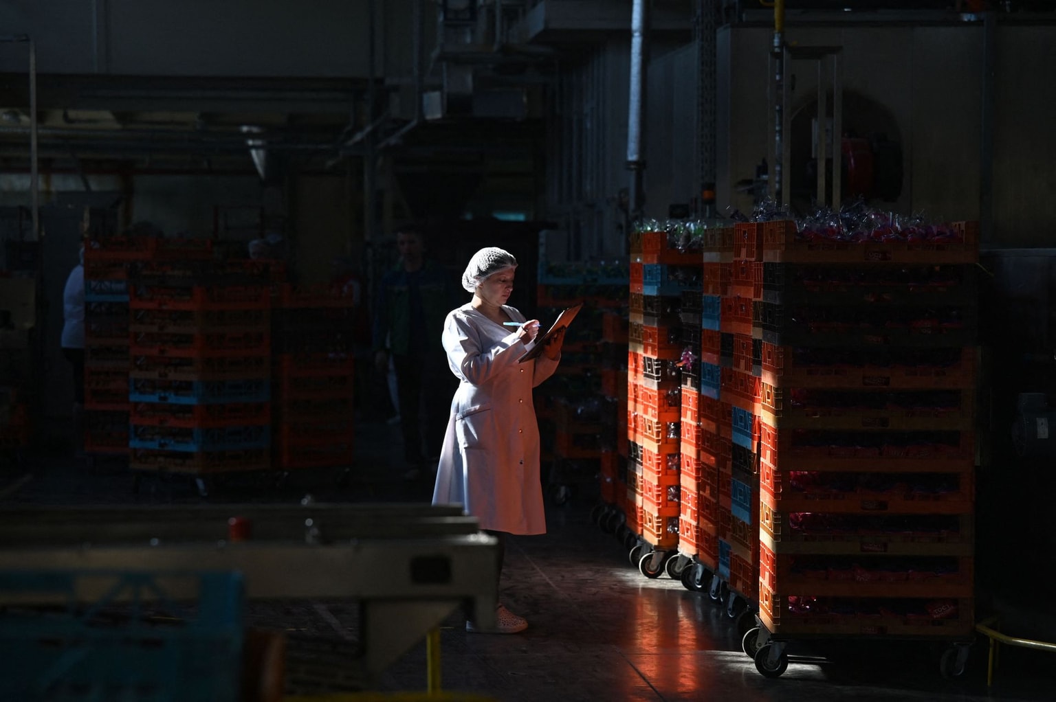 An employee counts trays of bread at the bread factory near Kyiv, Ukraine, on May 25, 2022.