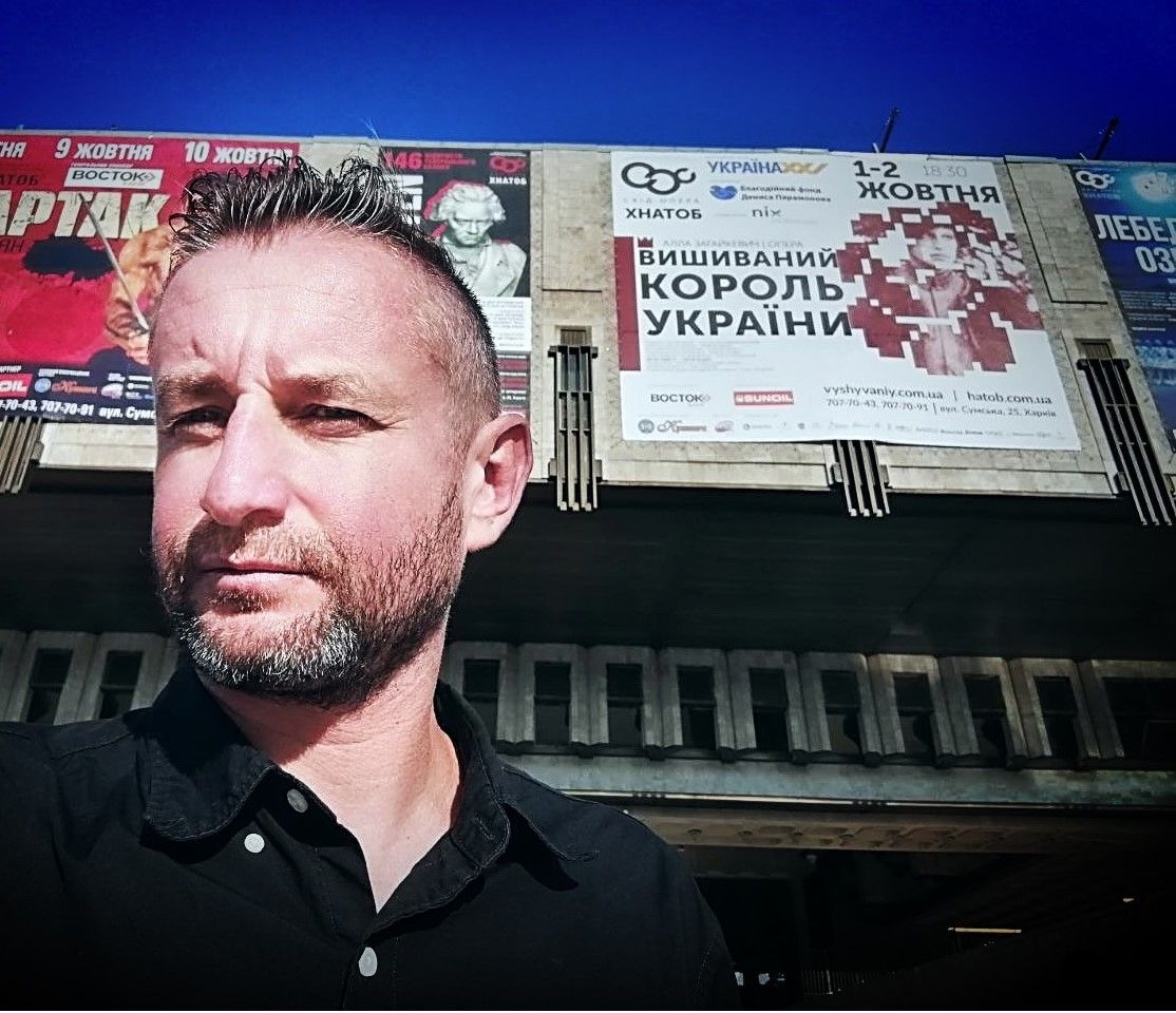 Serhii Zhadan in front of "Vyshyvanyi: The King of Ukraine" billboard in an undated photo.