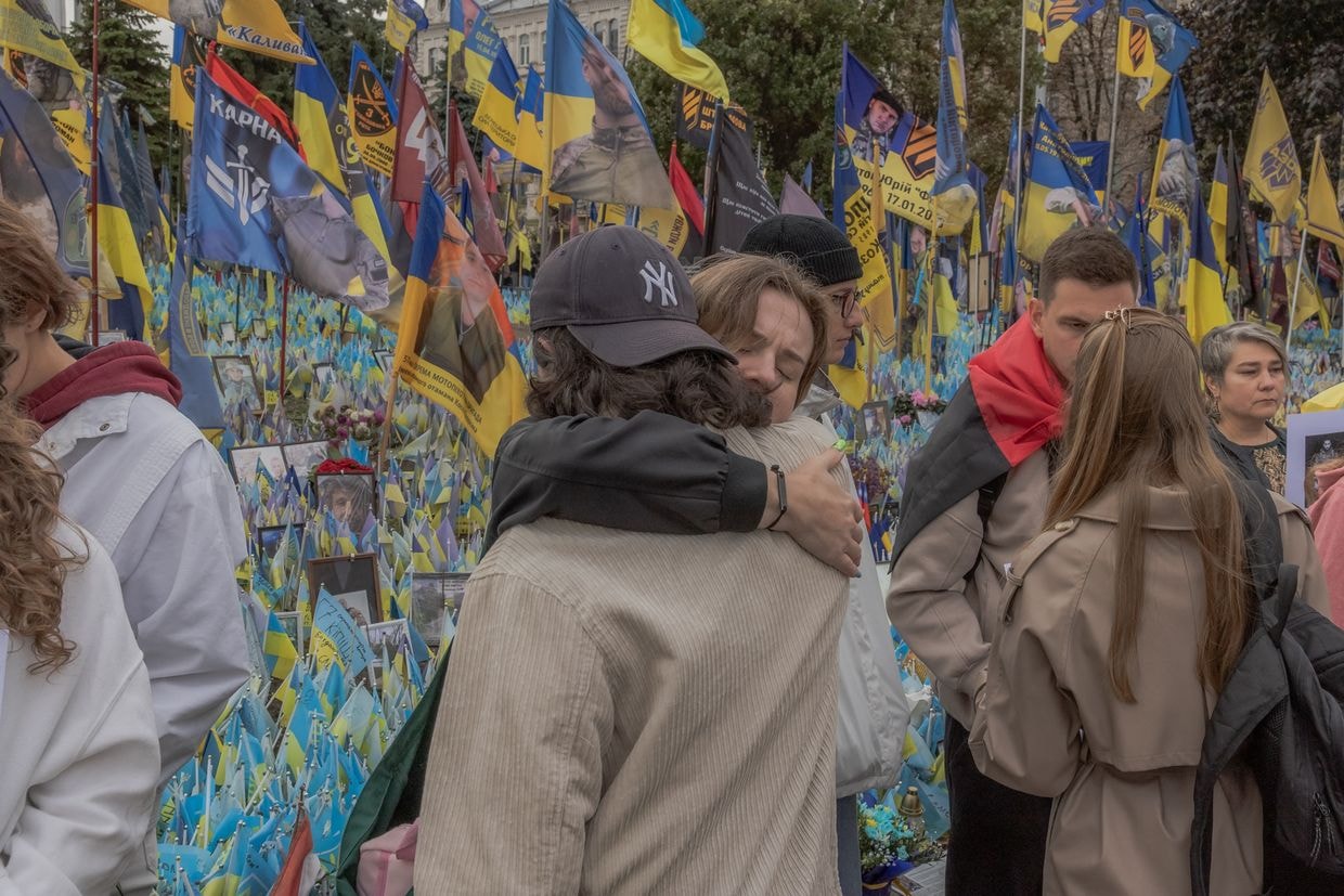 Two attendees embrace at a memorial for Ukrainian and foreign fighters on Defenders Day in Kyiv, Ukraine, on Oct. 1, 2024.
