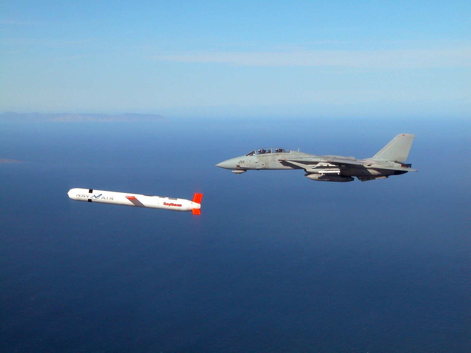 A Tactical Tomahawk Block IV cruise missile is escorted by a U.S. Navy F-14 Tomcat during a test over southern California on Nov. 10, 2002.