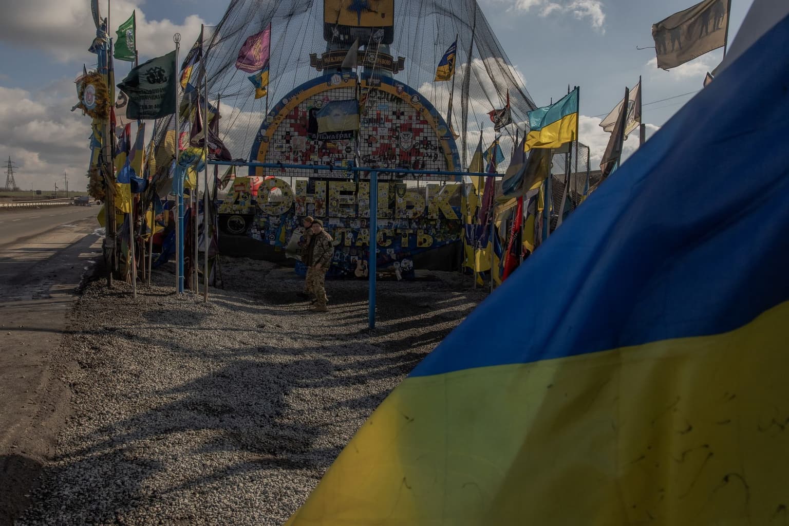 Donetsk Oblast entrance sign, protected by anti-drone netting and surrounded by Ukrainian brigade flags, on Feb. 2, 2025.