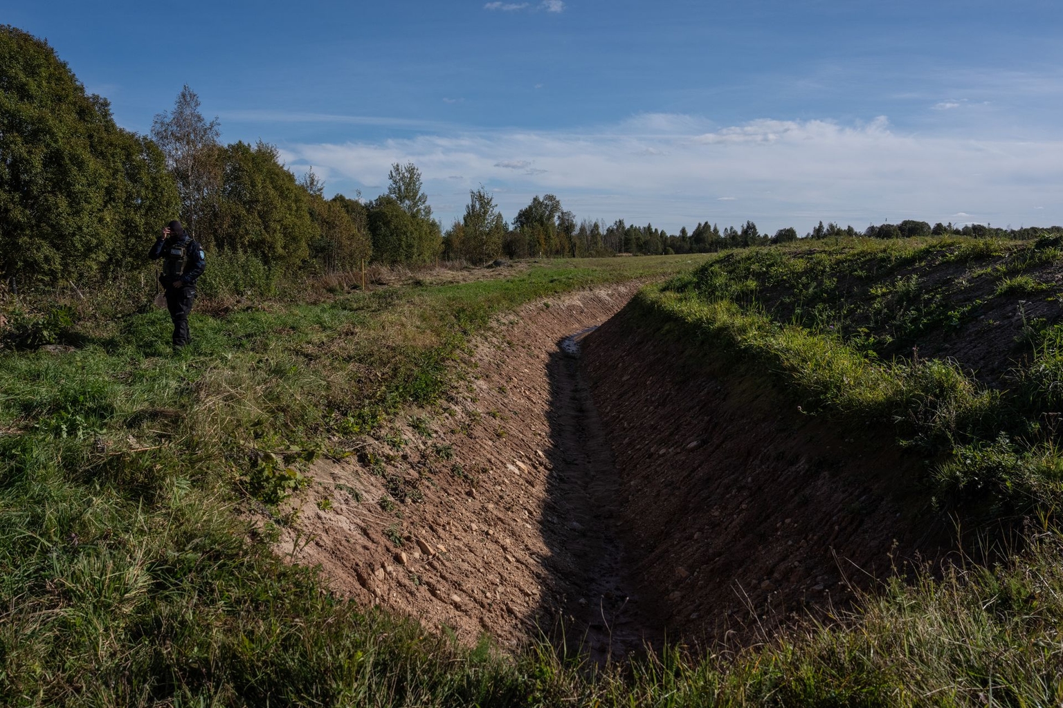 An Estonian border police officer stands next to a tank trench near the Estonian-Russian border in Vinski, Estonia, on Oct. 1, 2025.