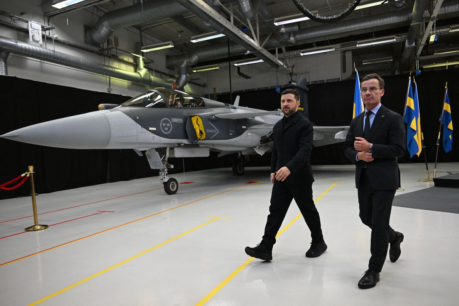 Swedish Prime Minister Ulf Kristersson and President Volodymyr Zelensky walk past a Gripen fighter jet after a joint press conference in Linköping, Sweden, on October 22, 2025.