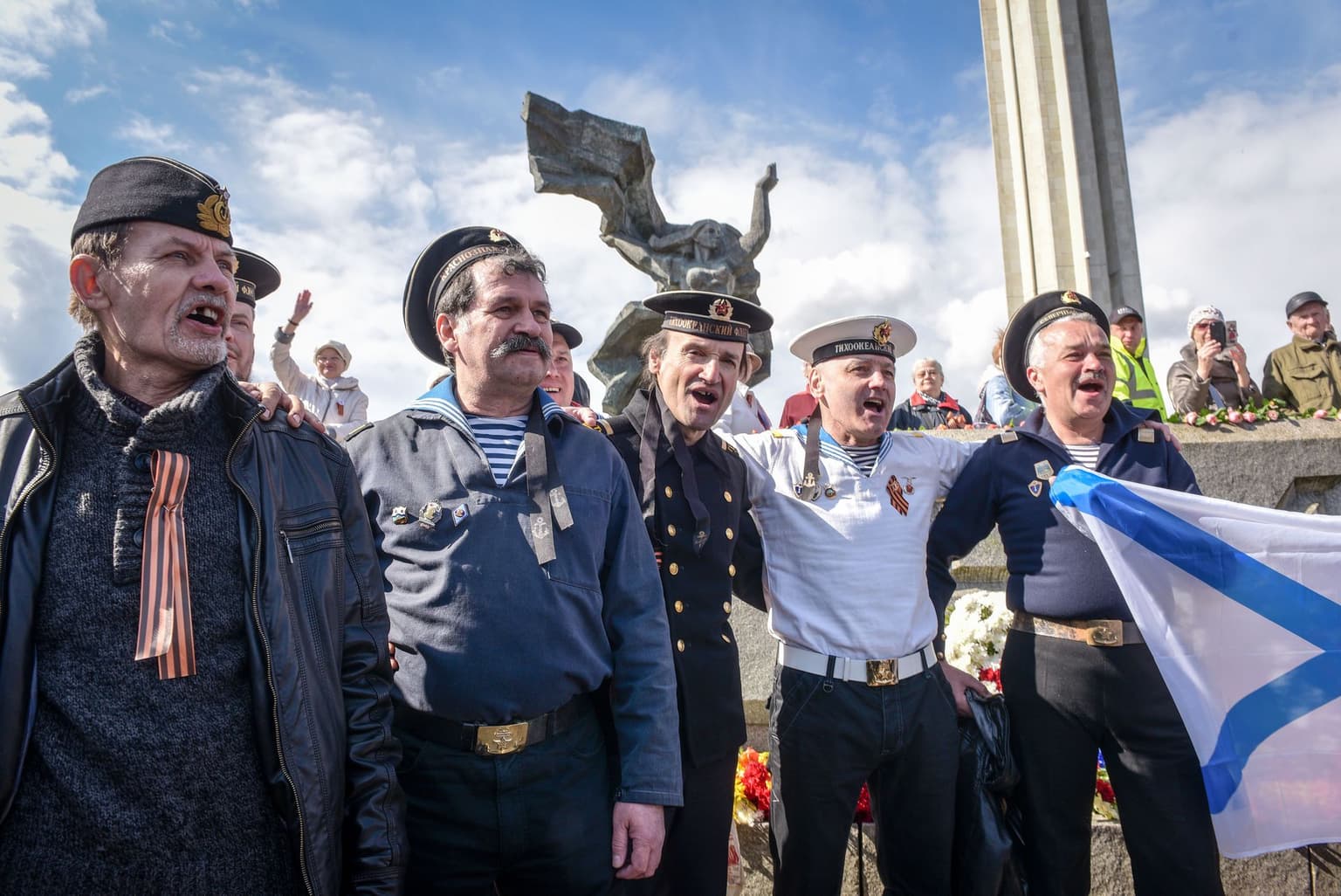 Men dressed in military uniforms with soviet insignia near the monument to the Soviet Army in Riga, Latvia, on May 9, 2017.