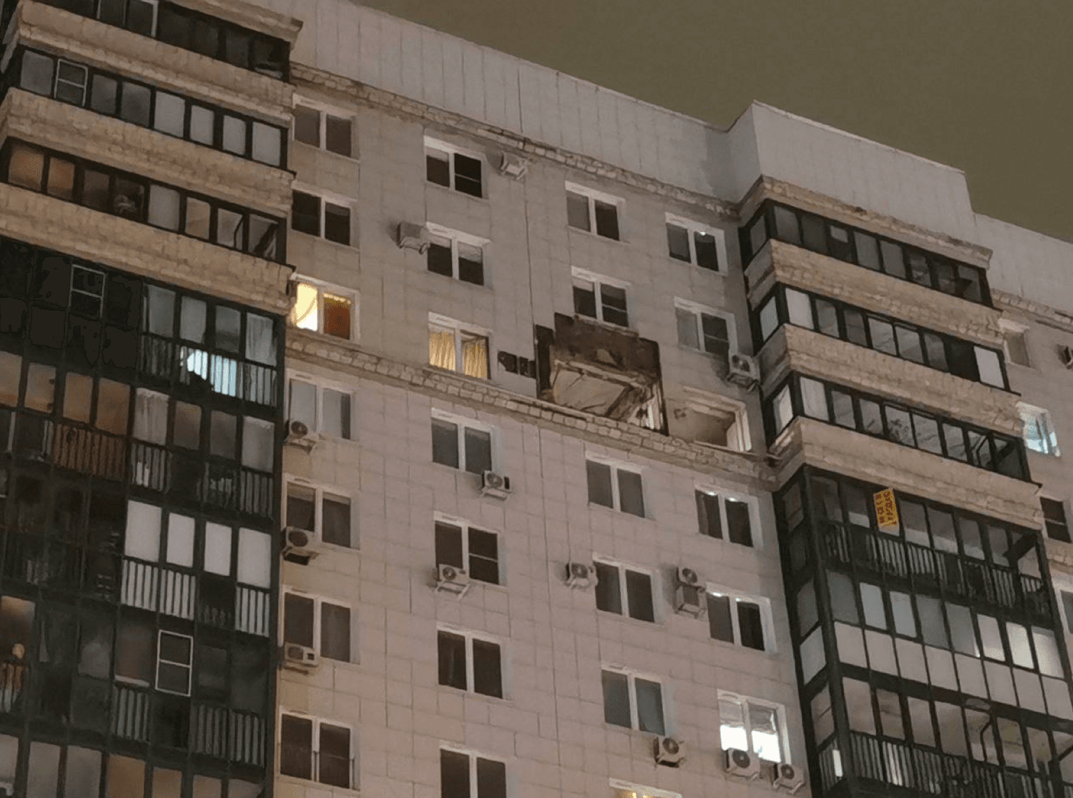 A residential building missing an exterior panel on a higher level
