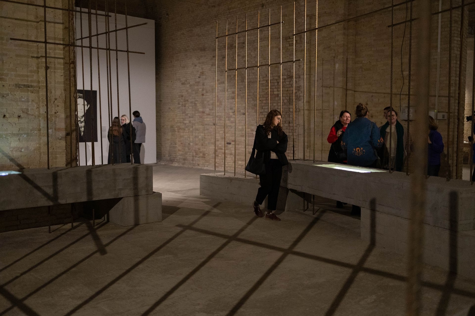 Visitors walk among prison cell bars at the exhibition dedicated to poet Vasyl Stus in Kyiv, Ukraine on Nov. 13, 2025.
