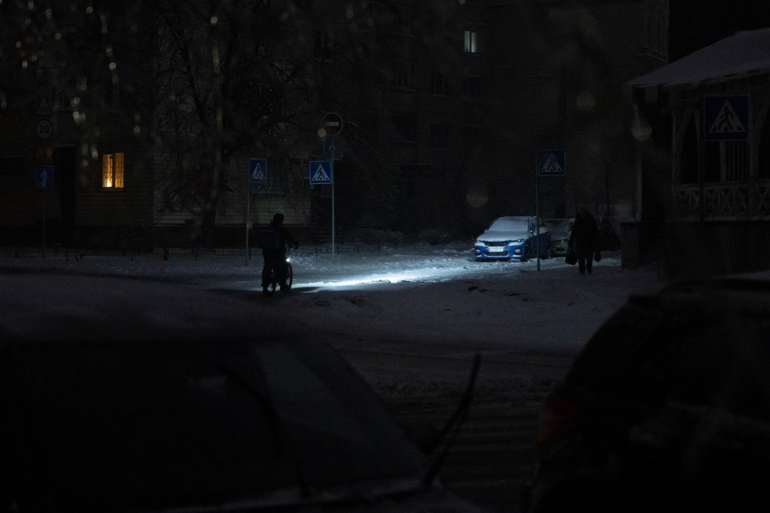 A person rides a bicycle on a non-illuminated street during a power outage in Kyiv, Ukraine, on Jan. 9, 2026.