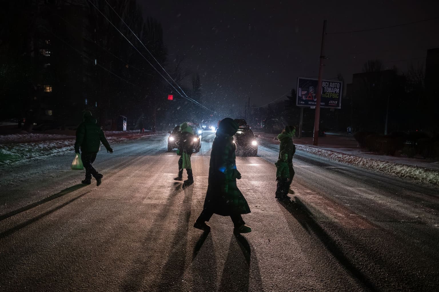 People cross a street during a power outage caused by recent Russian attacks in Kyiv, Ukraine, on Jan. 11, 2026.