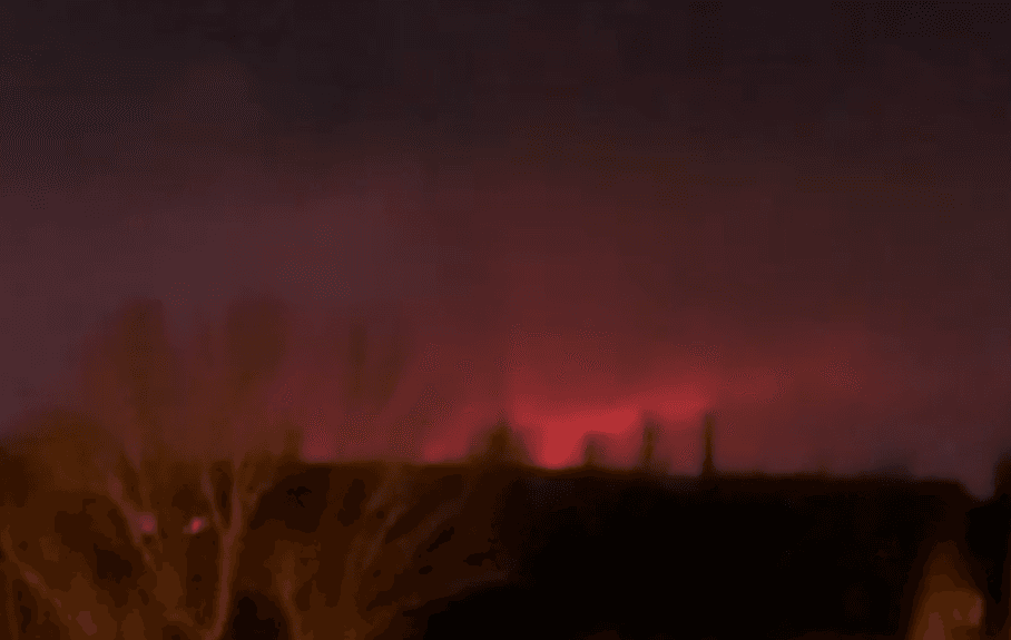 A red glow in the night sky in the distance