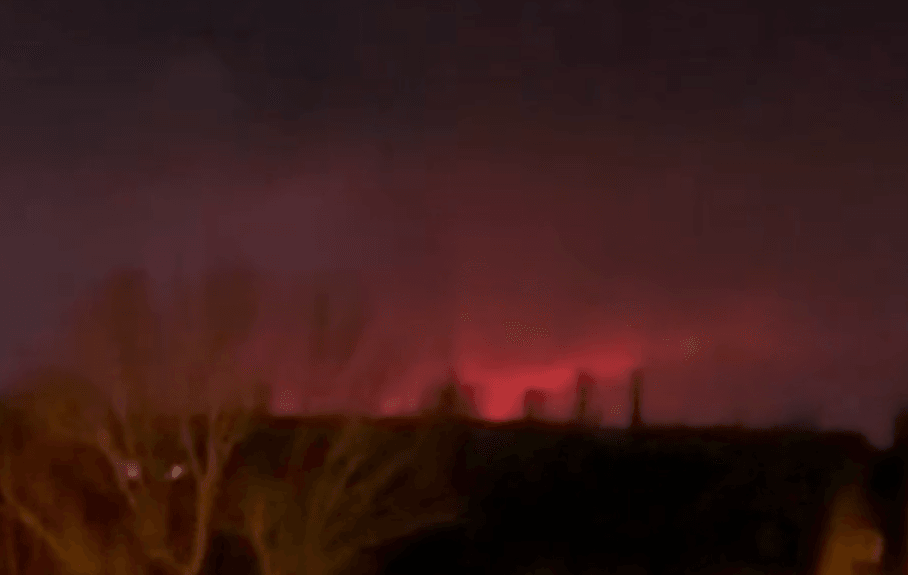 A red glow in the night sky in the distance