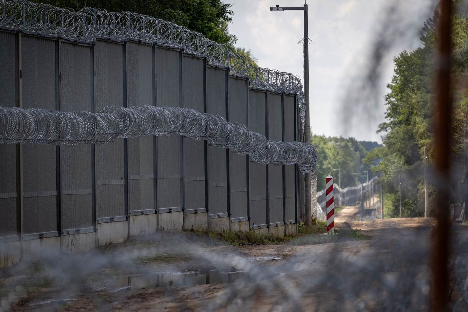 A barbed-wire fence and Polish border post are seen at the Polish-Belarusian border on July 21, 2025.