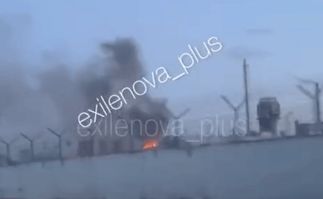 Dark smoke rises from a fire at an industrial enterprise