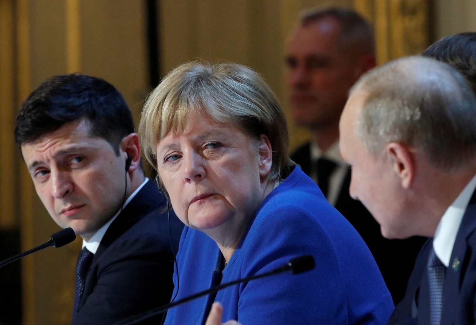 President Volodymyr Zelensky and then-German Chancellor Angela Merkel listen to Russian President Vladimir Putin during a press conference after a summit on Ukraine at the Elysee Palace in Paris, France, on Dec. 9, 2019