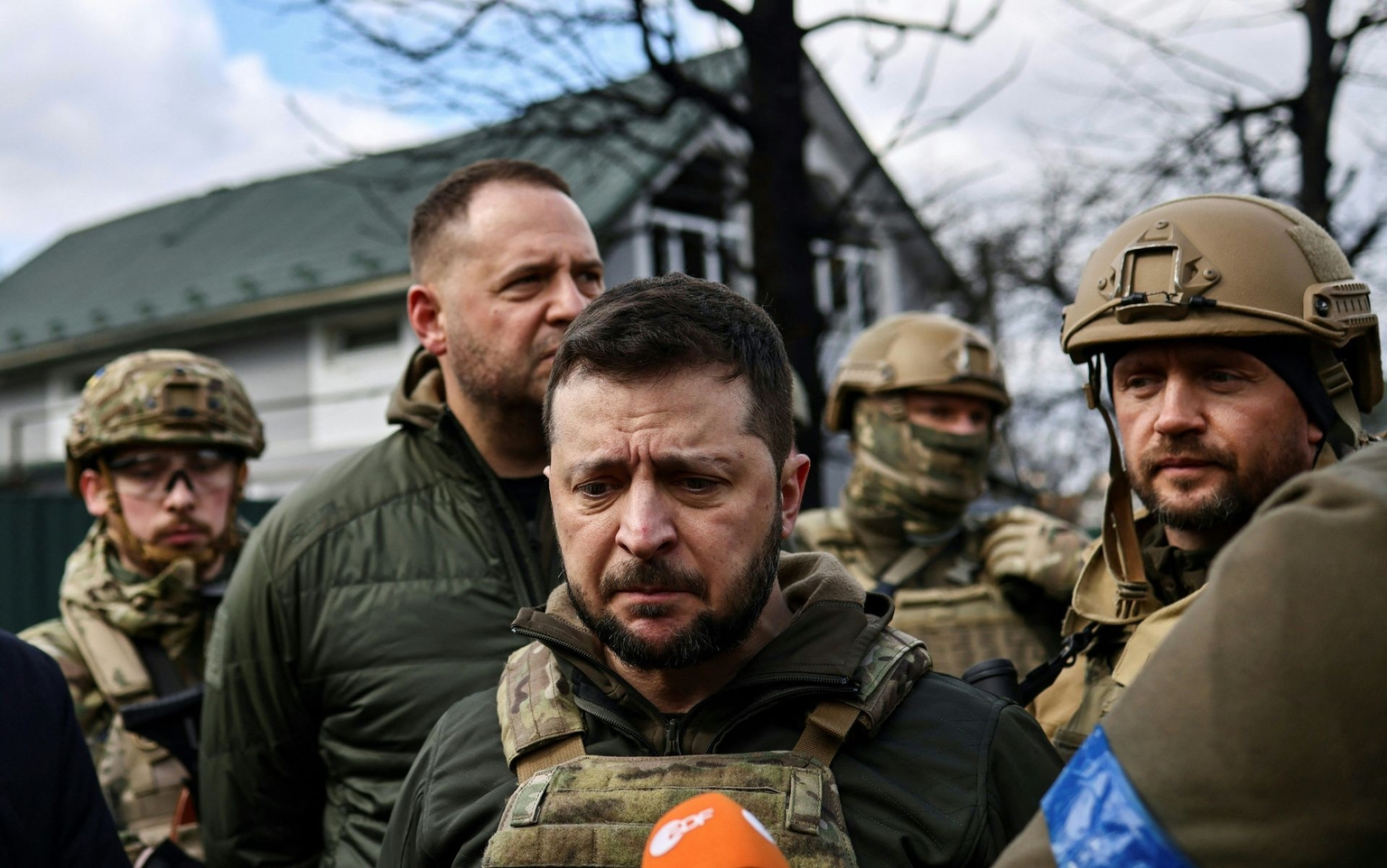 President Volodymyr Zelensky (C) speaks to the press in Bucha, Kyiv Oblast, on April 4, 2022.