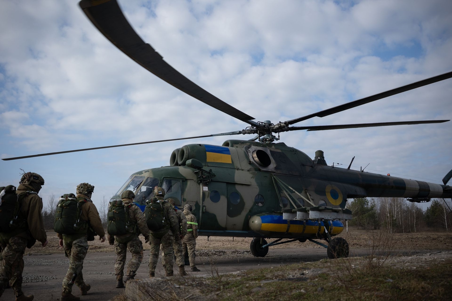 Ukrainian paratroopers head to a Mil Mi-8 helicopter to practice parachute jumps at a training ground in an unspecified location, Ukraine, on March 27, 2026.