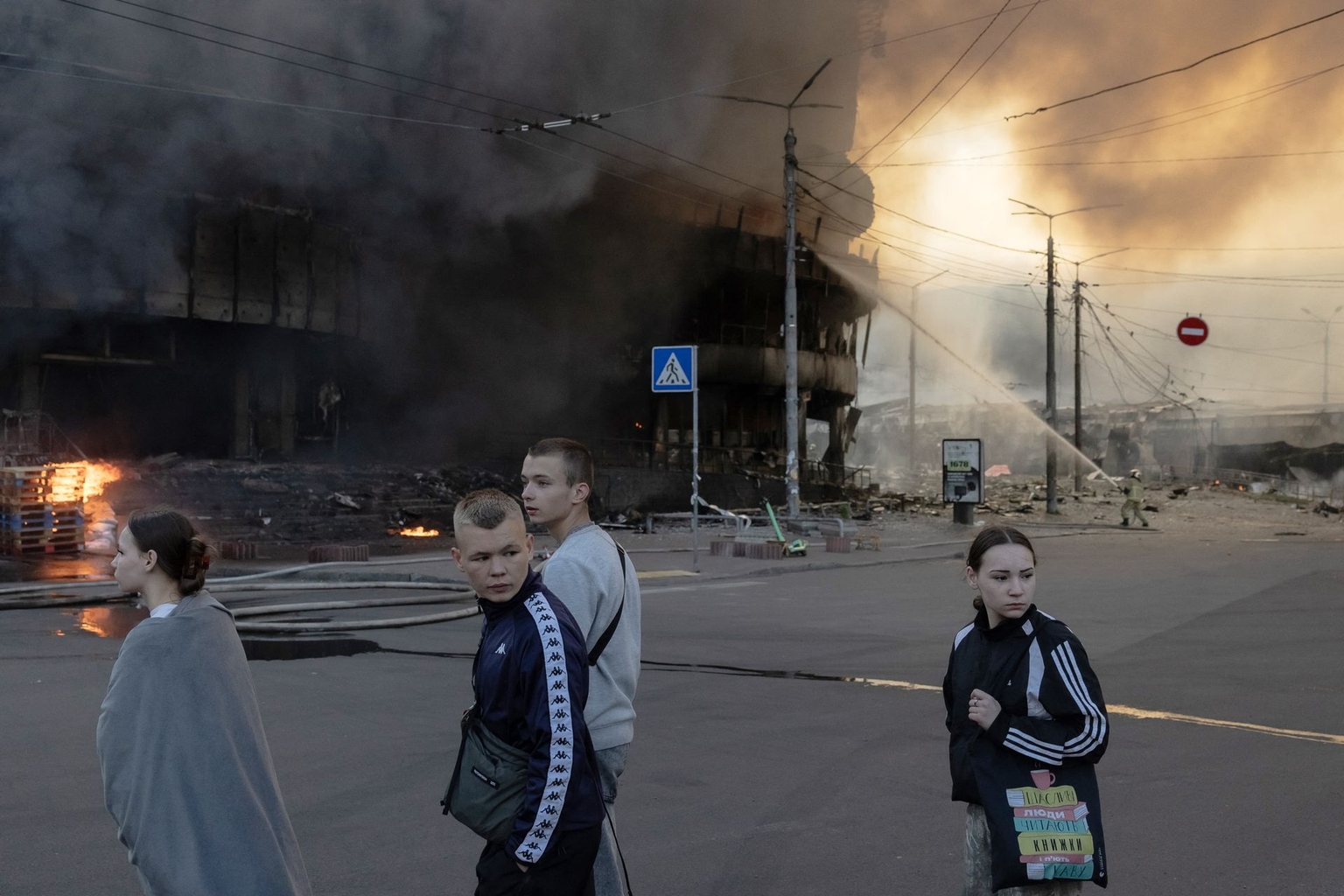 People walk past a shopping center on fire following Russian strikes in Kyiv, Ukraine, on May 24, 2026.