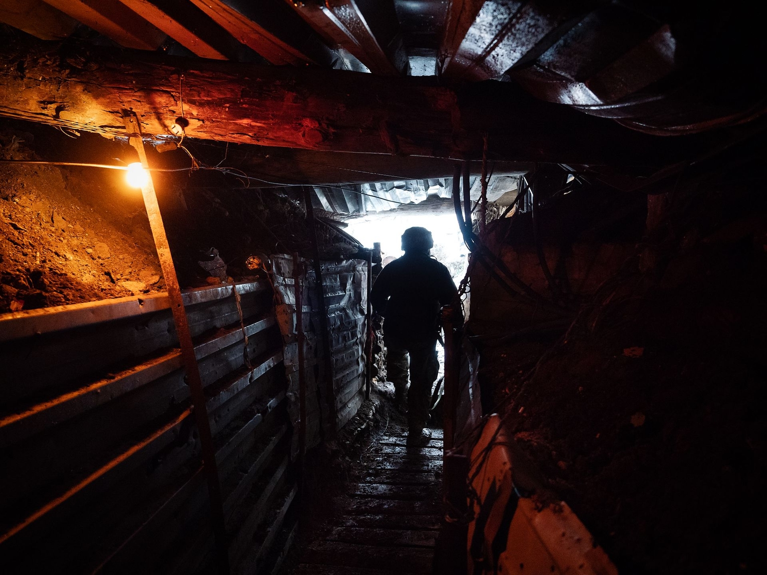 A Ukrainian soldier walks through an underground trench in Pisky, Donetsk Oblast, Ukraine, on Feb. 9, 2022.